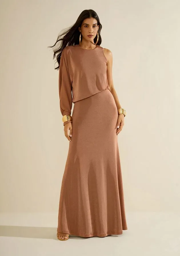 Modelo com conjunto de blusa de manga única e saia longa cobre