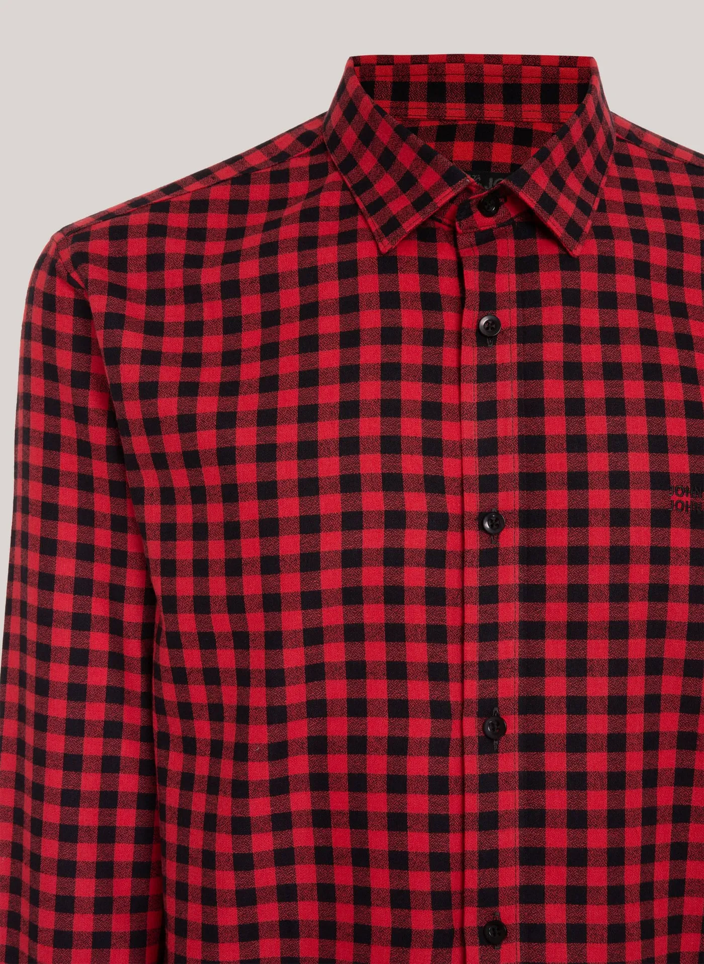 Detalhe da camisa xadrez vermelha e preta